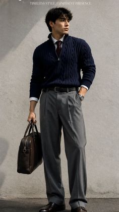 Man in a navy sweater and grey trousers holding a brown briefcase