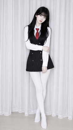 Woman with long black hair wearing a pinstripe vest and red tie with white tights