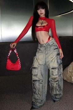 Woman in a red crop top and baggy jeans holding a red handbag