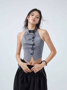 Woman in a gray halter top and black skirt with exposed midriff