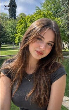 Young woman with long brown hair and freckles outdoors