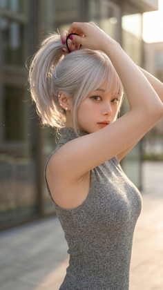 Woman with blonde hair in a grey dress tying her ponytail outdoors