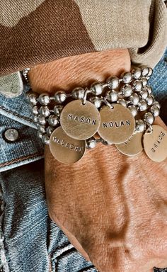 Close up of a person's arm wearing a beaded bracelet with name tags