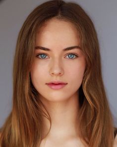 Young woman with long light brown hair and blue eyes in a portrait shot
