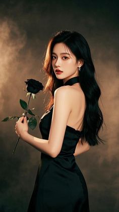 Woman in a black dress holding a black rose with dramatic lighting