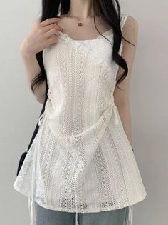 Woman with long black hair wearing a white lace top and a necklace