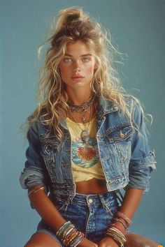 Woman with blonde hair in a denim jacket and crop top with layered jewelry