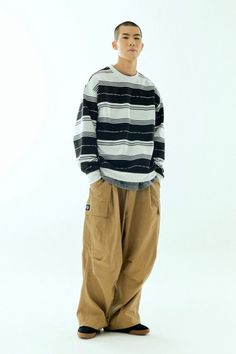 Person in a striped long-sleeve shirt and baggy cargo pants on a white background