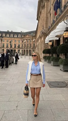 Woman in a mini skirt and striped shirt walking on a city street