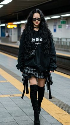 Woman with long black hair and sunglasses in a subway station