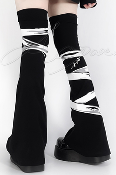 Person wearing black pants with white stripes and platform shoes