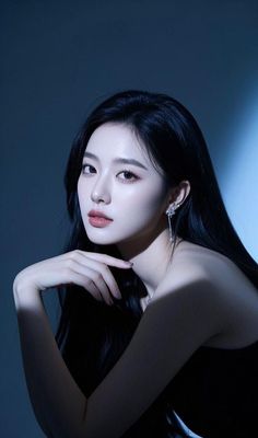 Woman with long black hair and jewelry in dramatic lighting