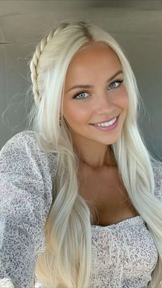 Smiling woman with long blonde hair and blue eyes wearing a floral top