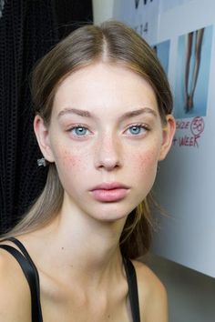 Woman with blue eyes and freckles looking directly at the camera