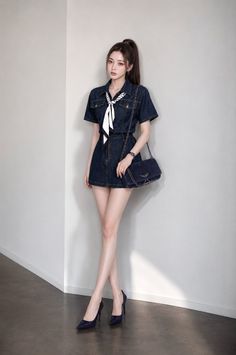 Woman in a denim dress and high heels posing indoors