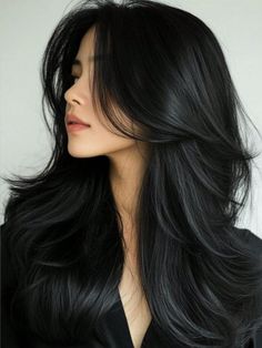 Woman with long, layered black hair in a side profile shot