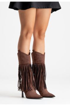 Woman's legs in brown fringe boots and a short black skirt