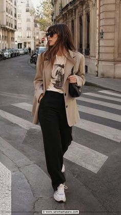 Woman in a blazer and black pants walking on a city street