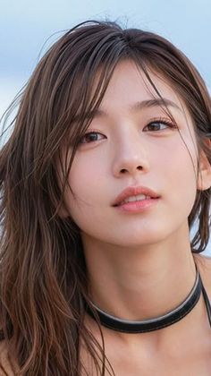 Woman with wet long hair and a choker looking directly at the viewer