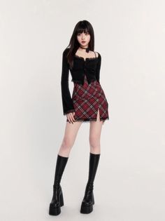 Woman with long black hair wearing a plaid skirt and black boots
