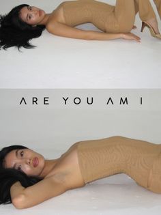 Woman with long black hair wearing a strapless top and tan pants, lying on a white surface