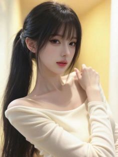 Woman with long black hair in a ponytail wearing an off-shoulder top