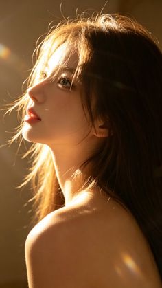 Woman with long hair looking up, bathed in golden hour sunlight