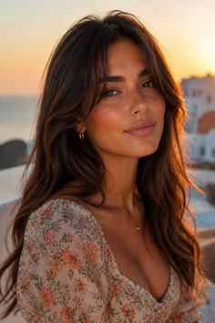 Woman with long brown hair in a floral dress at golden hour