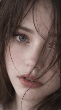 Close up portrait of a woman with long brown hair and green eyes
