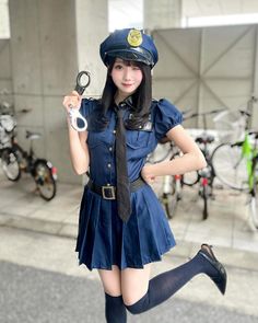 Woman in a police uniform holding handcuffs and winking