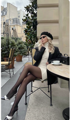 Woman in a beret and mini dress sitting at an outdoor cafe
