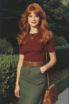 Woman with red hair wearing a maroon top and green skirt outdoors