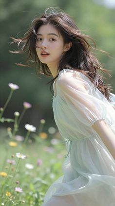 Woman with long hair in a light dress in a field of flowers