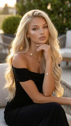 Blonde woman in a black off-shoulder dress with jewelry at golden hour