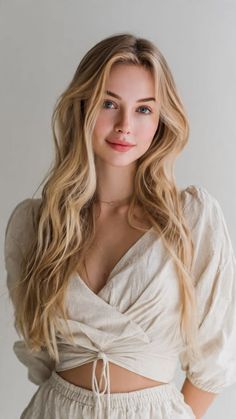 Blonde woman with blue eyes wearing a crop top, looking at the camera