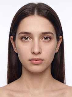 Woman with long dark hair and brown eyes against a white background