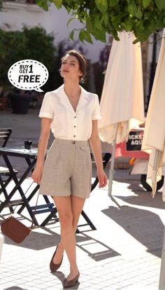 Woman in a white shirt and high-waisted shorts walking outdoors