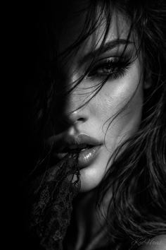 Close up black and white portrait of a woman with wet hair and lace in her mouth