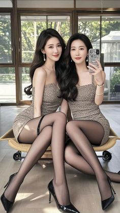 Two women in short dresses and black pantyhose posing indoors