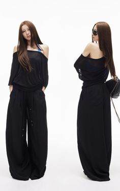 Woman in black off-shoulder top and wide-leg pants posing in a studio