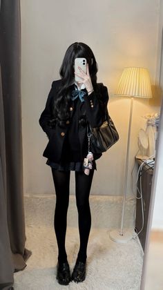 Person in a school uniform taking a mirror selfie indoors