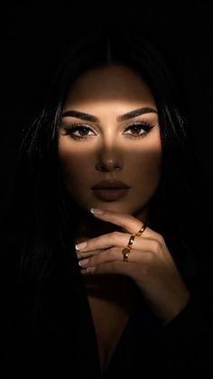 Woman with long dark hair and dramatic lighting across her face