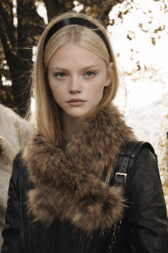 Young woman with blonde hair and freckles wearing a fur collar and leather jacket