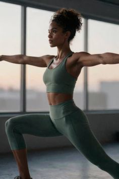 Woman in athletic wear doing a yoga pose indoors with natural light