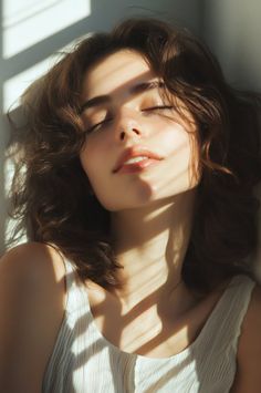 Woman with closed eyes and brown hair, illuminated by soft light and shadows
