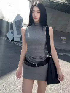 Woman in a tight gray dress and black belt outdoors