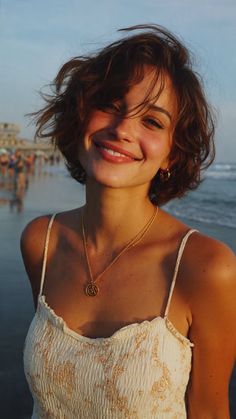 Smiling woman with short hair on a beach at golden hour
