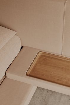 Close up of a beige sofa with an integrated wooden tray