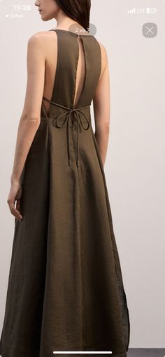 Woman in a long, dark green dress with an open and tie-back design
