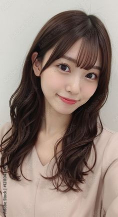 Woman with long brown hair and bangs wearing a v-neck top